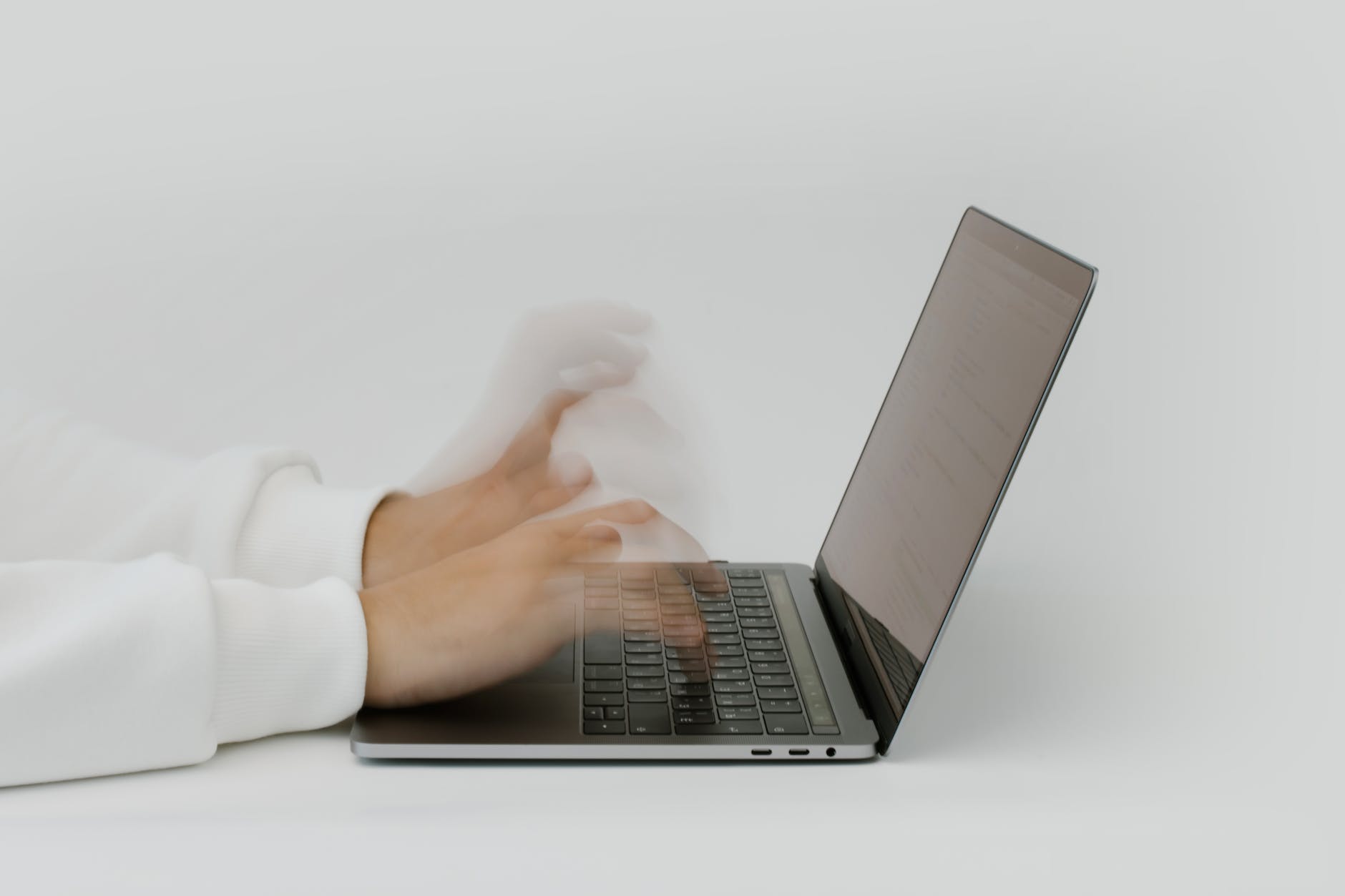 hands typing on a laptop keyboard